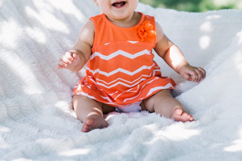 Baby Mädchen im orangefarbenen Kleid
